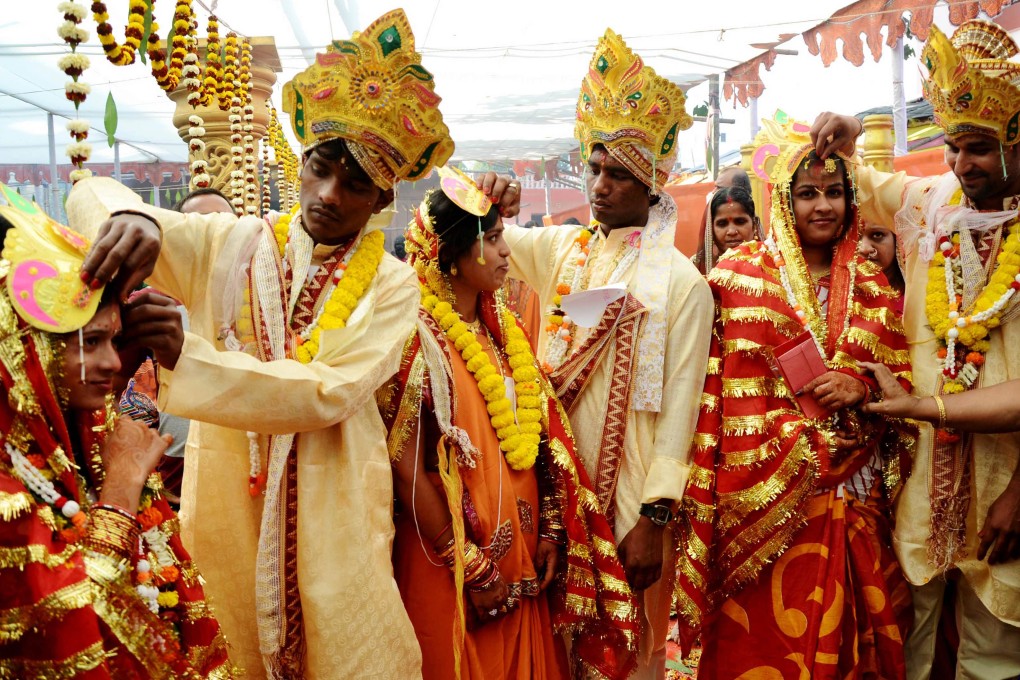Brides are marked with dots on their forehead during an Indian mass wedding. Many brides are hiring langurs and their handlers to ward away smaller monkeys. Photo: AFP