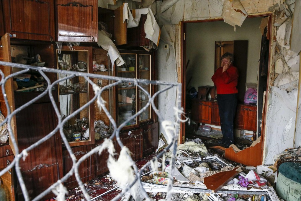 A woman surveys the debris inside her flat at a residential block damaged by a recent shelling near Donetsk on Tuesday.Photo: Reuters