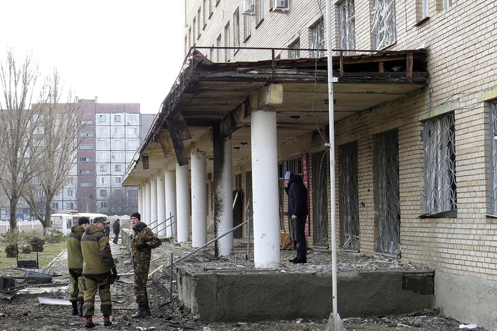 Members of the armed forces of the separatist self-proclaimed Donetsk People's Republic gather outside the hospital hit by shelling in Donetsk. Photo: Reuters