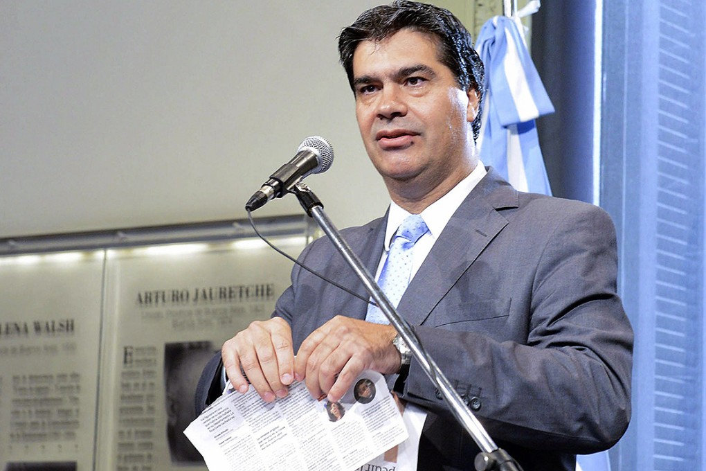 Argentina's cabinet chief, Jorge Capitanich, tears up a copy of the Clarin newspaper on Monday after it reported the existence of a warrant to arrest President Cristina Fernandez. Photo: EPA