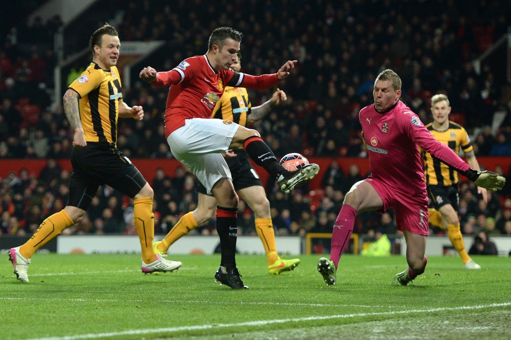 Manchester United's Robin Van Persie forces a save from Cambridge United's Chris Dunn during their FA Cup fourth round replay. Photo: EPA
