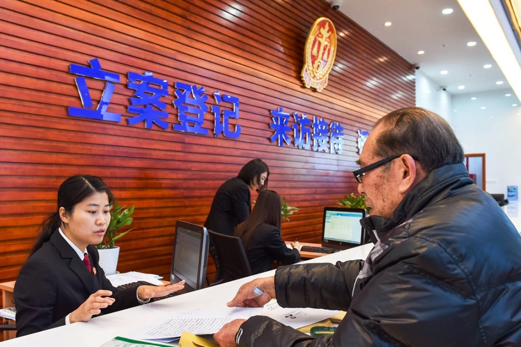 A court clerk (first left) of China's Supreme People's Court first circuit court receives a claimant at the reception room. Photo: Xinhua