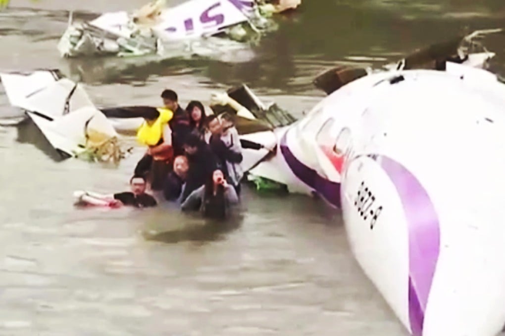Shocked survivors climb out of the wreckage of the plane after it crashed in Taiwan's Keelung River. Photo: Screengrab