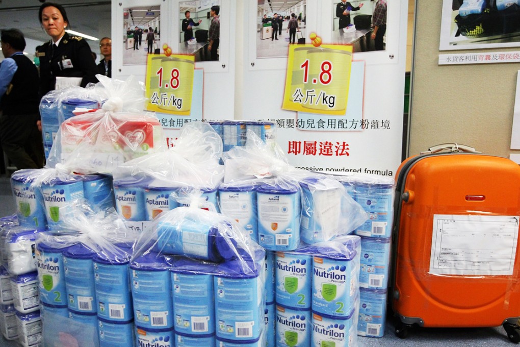 Customs officials show milk powder confiscated in Lo Wu. Photo: Felix Wong