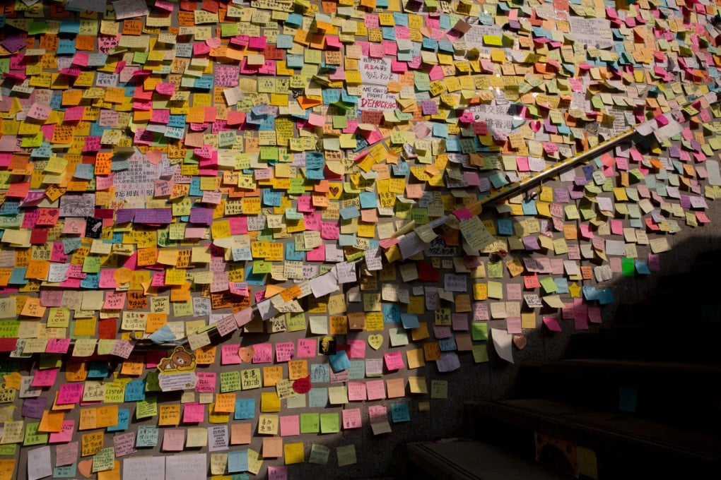 A wall outside government headquarters in Admiralty is plastered with pro-democracy messages in October, at the height of the “umbrella movement”. Photo: Bloomberg