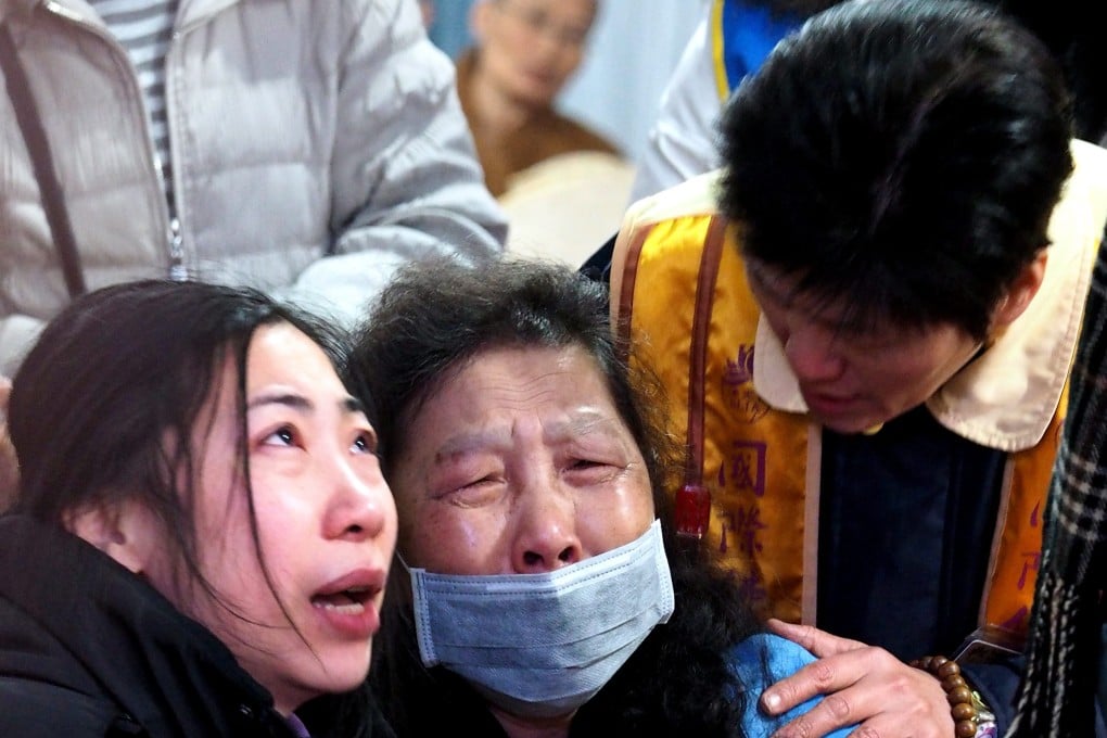 A man consoles two women at the funeral for victims of the TransAsia Airways plane crash. Photo: EPA