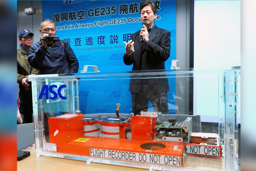 Thomas Wang (right), executive director of the Aviation Safety Council, standing behind a black box, reveals initial findings from the crash. Photo: EPA