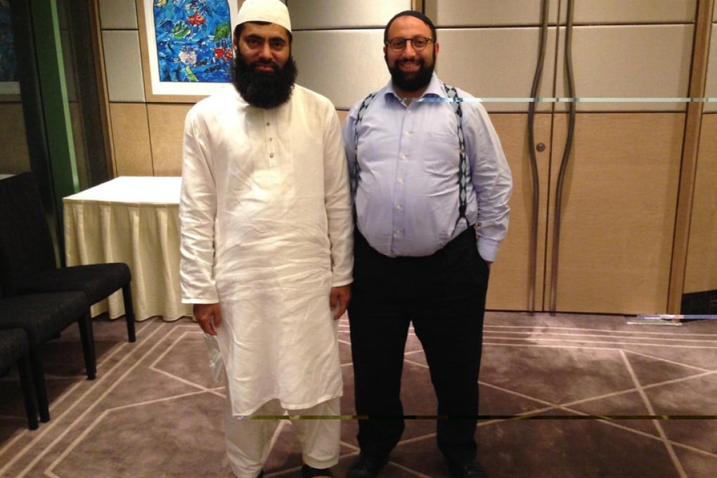 Muhammad Arshad (left) and Asher Oser reach out to each other.