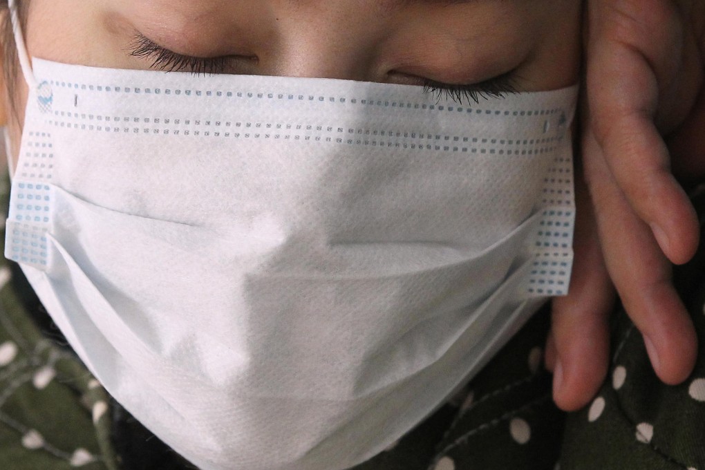An exhausted patient waits for treatment at Yau Ma Tei's Queen Elizabeth Hospital yesterday. The city's public health system is struggling amid the winter flu outbreak. Photo: Edward Wong