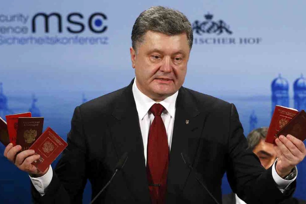 President Petro Poroshenko brandishes Russian passports, which, he says, prove the presence of Russian troops in Ukraine. Photo: Reuters