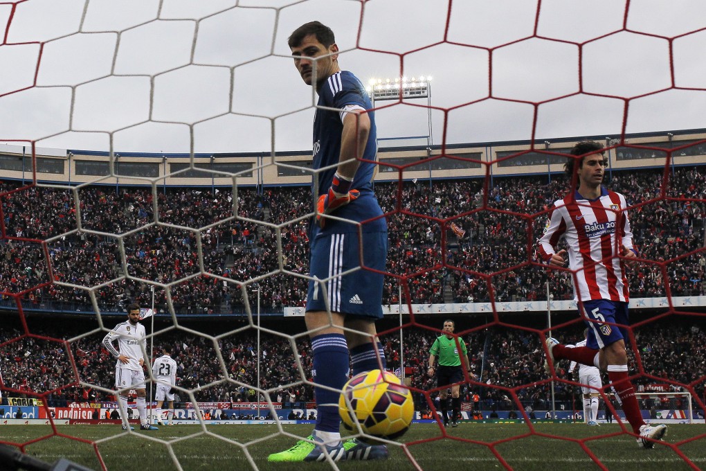 Atletico's Tiago celebrates Mario Mandzukic's  goal as Real Madrid goalkeeper Iker Casillas contemplates what went wrong. Photo: AP