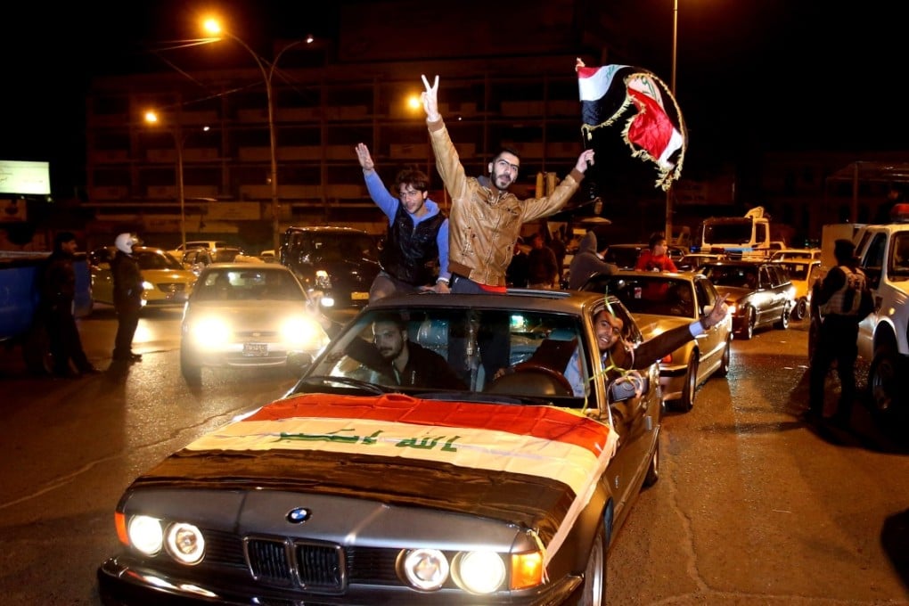 Iraqis celebrate after the lifting of the night-time curfew at Tahrir Square in Baghdad, Iraq. Photo: AP