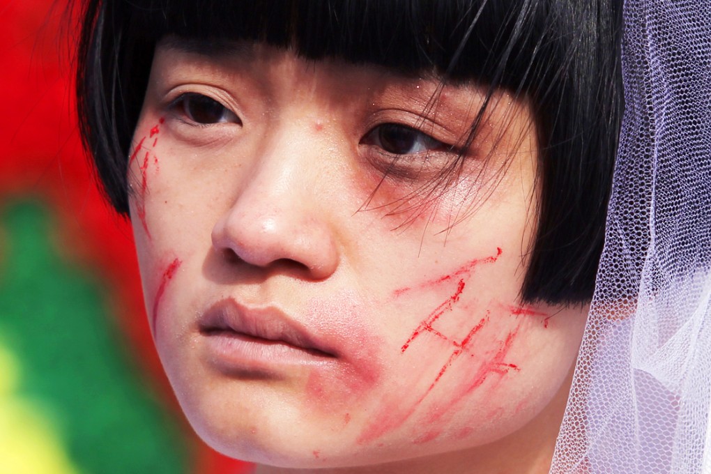 A woman dresses up with bloody wedding gowns to campaign for domestic violence victims on Valentine's day in 2012. For safety reasons, women must seek short-term residence at shelters outside the district they live in and shelter locations are kept confidential. Photo: Simon Song