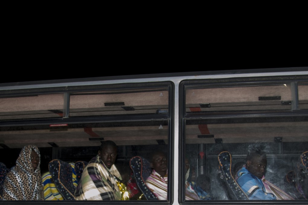 Survivors from among a group of African migrants rescued at sea sit on a bus in Lampedusa, Italy, on Monday. Photo: AP