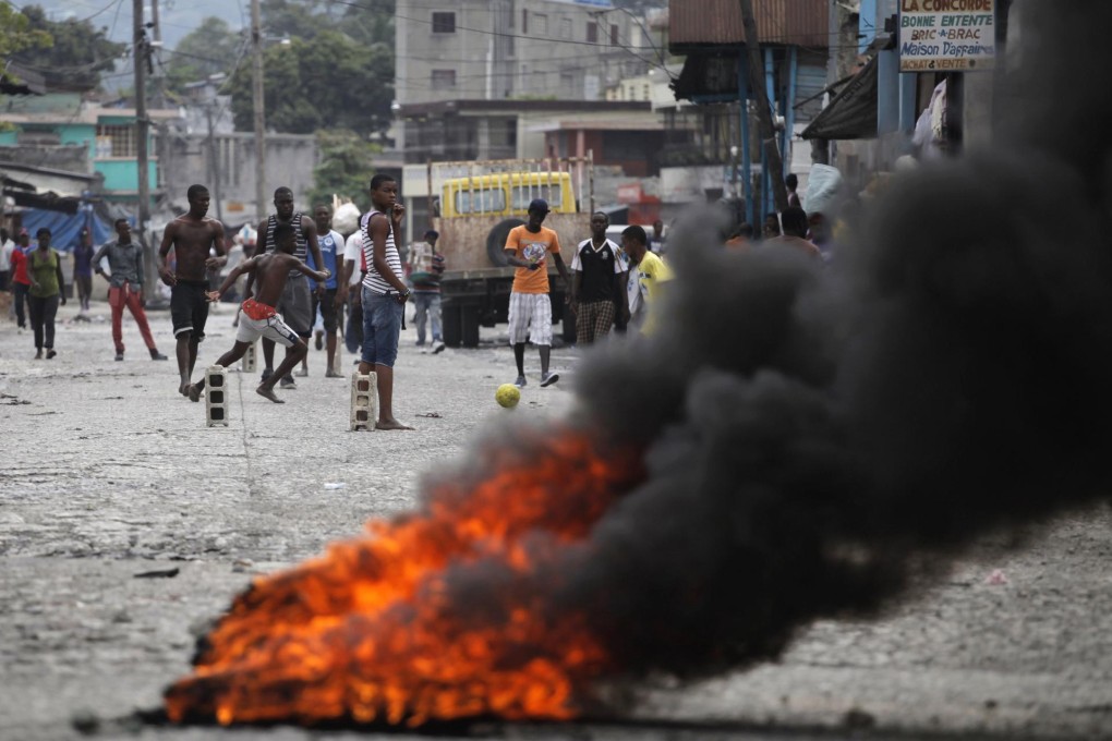 Haitian youths play street soccer by burning tyres.Photo: Reuters