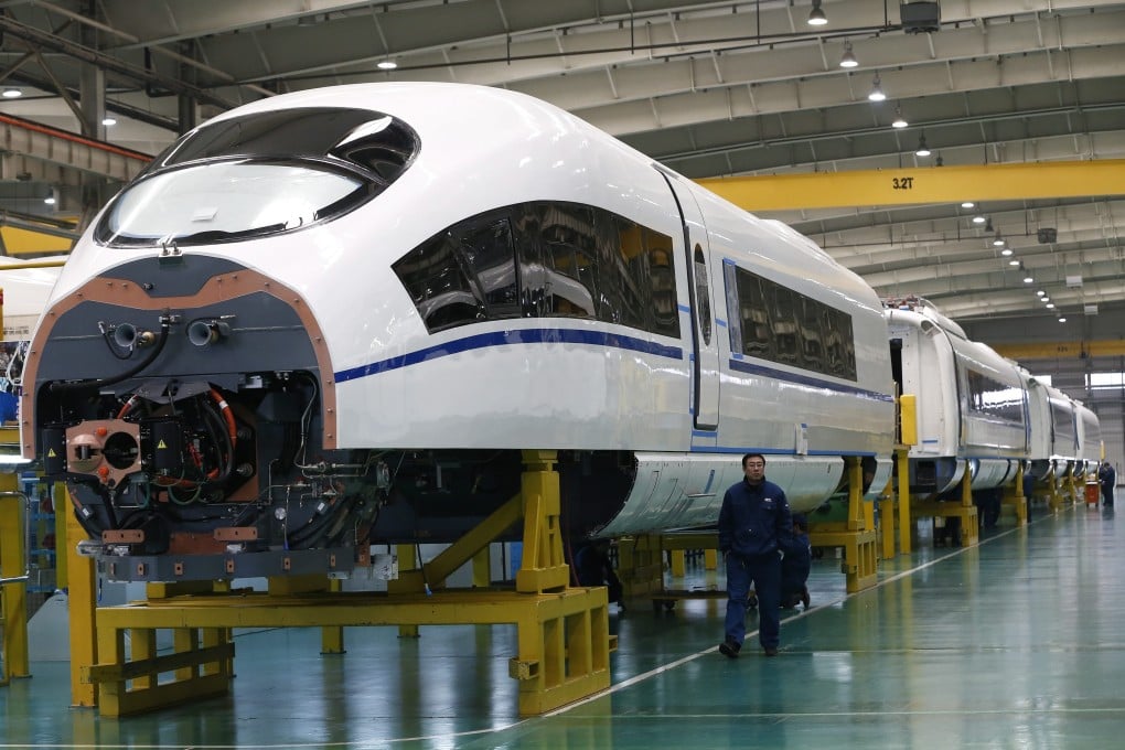 Worker passes by almost completed high-speed train in Tangshan city in Hebei province in China. Photo: EPA