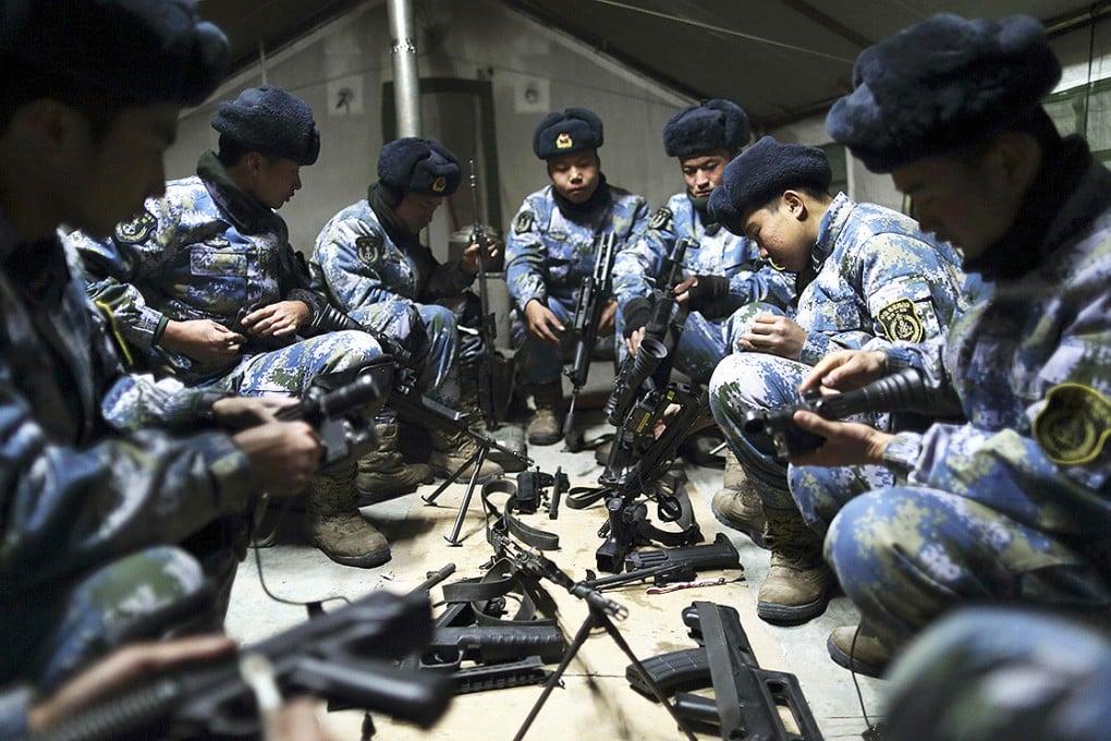 Soldiers of the People's Liberation Army (PLA) Marine Corps clean their rifles inside a tent during a military drill at a military base in Taonan. Photo: Reuters