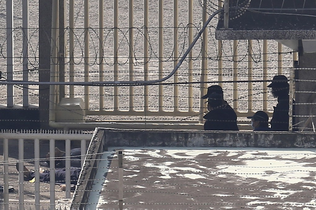 Police officers examine the bodies of hostage-takers this morning at Kaohsiung Prison in southern Taiwan. Photo: Reuters