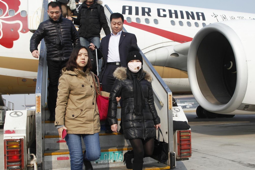 An alleged 'economic fugitive' (wearing mask) arrives in China last week after 10 years on the run in Italy. Photo: Xinhua