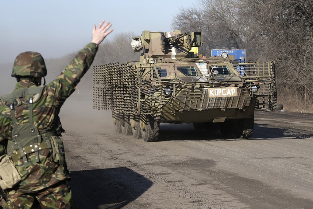 A Ukrainian soldier waves to an armoured vehicle outside the town of Artemivsk. Photo: AP