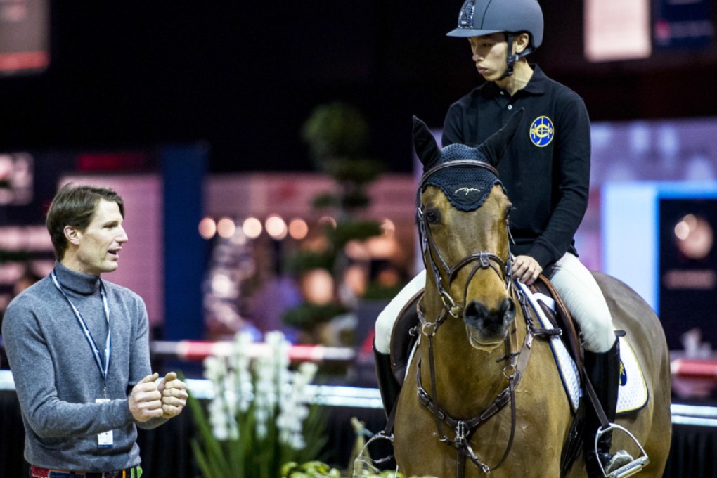 Vincent Ho Chak-yiu listens to the advice of Frenchman Kevin Staut at the AsiaWorld-Expo during a practice ahaed of Friday night's Race of the Riders. Photos: SCMP Pictures