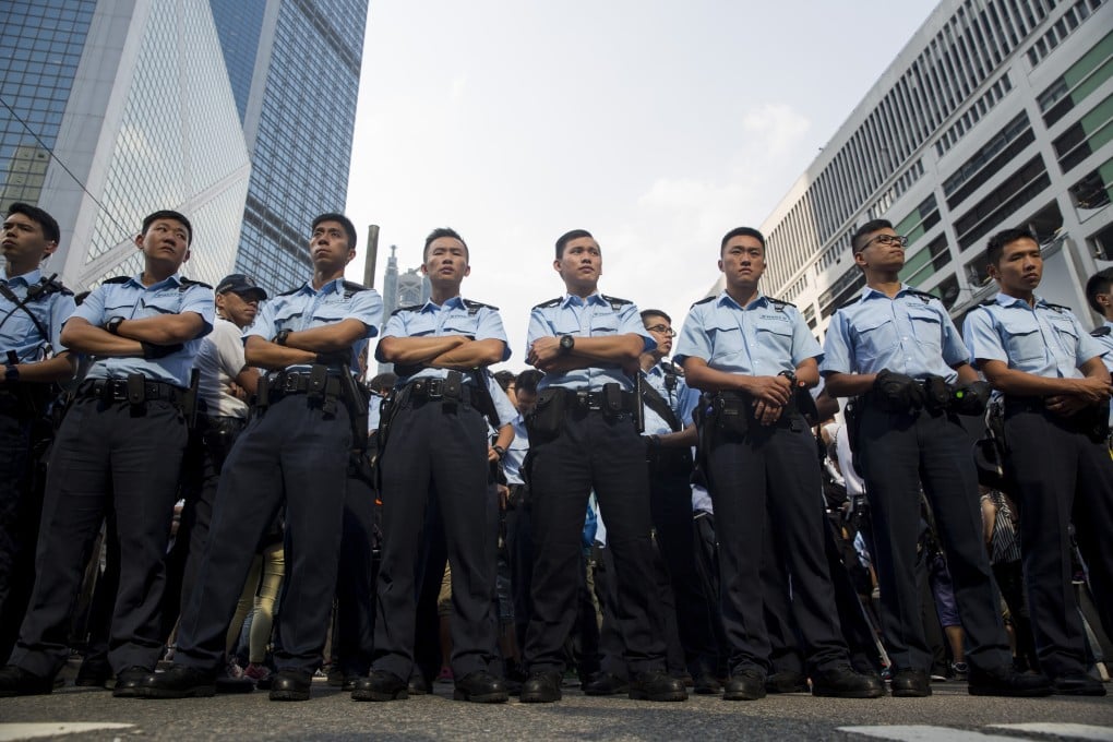 Police stand guard in the central business district of Hong Kong during the pro-democracy demonstrations. The latest manpower boost plan is likely to reignite the debate over how the police handled the Occupy protests. Photo: Bloomberg