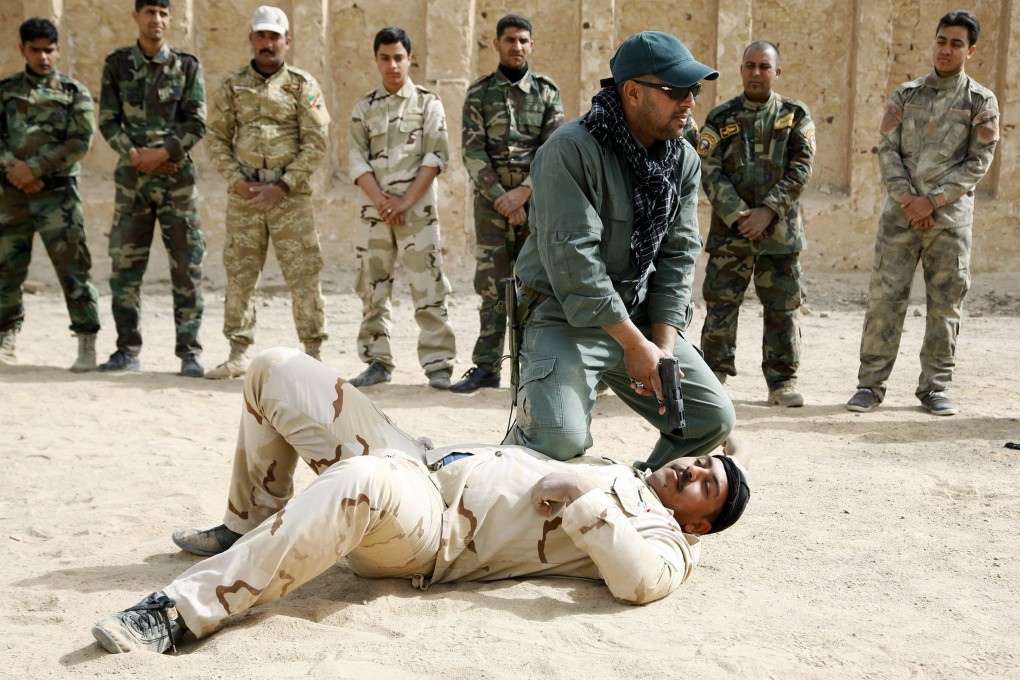 Shiite volunteers receive martial arts training at a military base in southern Iraq. The volunteers have been assisting the Iraqi army as it battles fighters from Islamic State, fighting off a major offensive near the Ain al-Asad air base. Photo: EPA