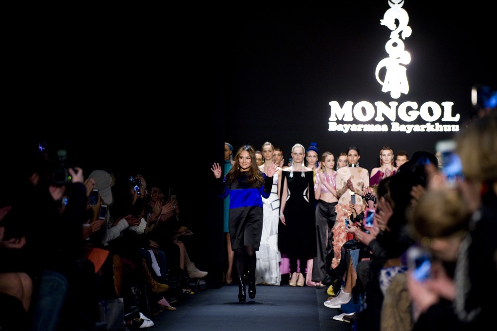 Bayarmaa Bayarkhuu waves on the catwalk after the show for her label Mongol in New York. Photo. EPA