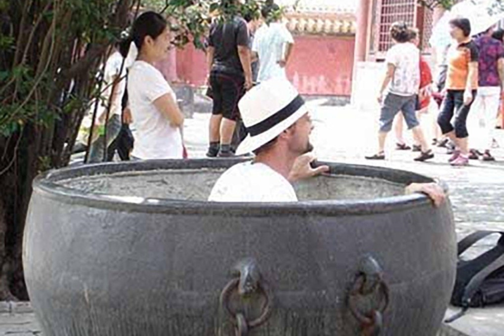 A tourist steps into a precious monument to pose for a photo. Photo: SCMP Pictures