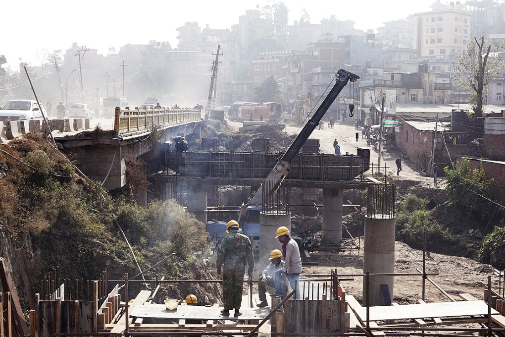 A Chinese supervisor (left) and local workers labor on a construction site at a ring road being upgraded to an eight-lane highway in Kathmandu, Nepal. Photo: Bloomberg
