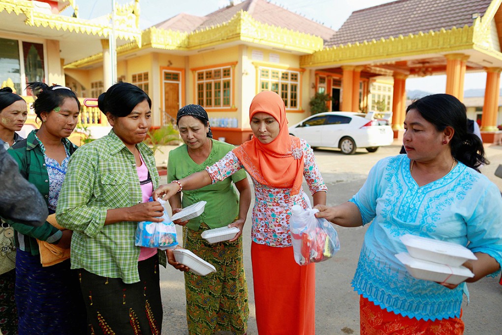 Women provide food to people who have been displaced by fighting, at a temporary refugee camp in a monastery in Lashio. Photo: Reuters