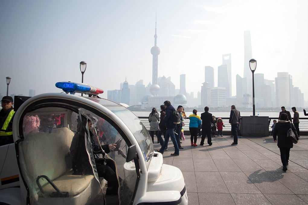 A police officer patrols along the promenade on the Bund. Photo: AFP