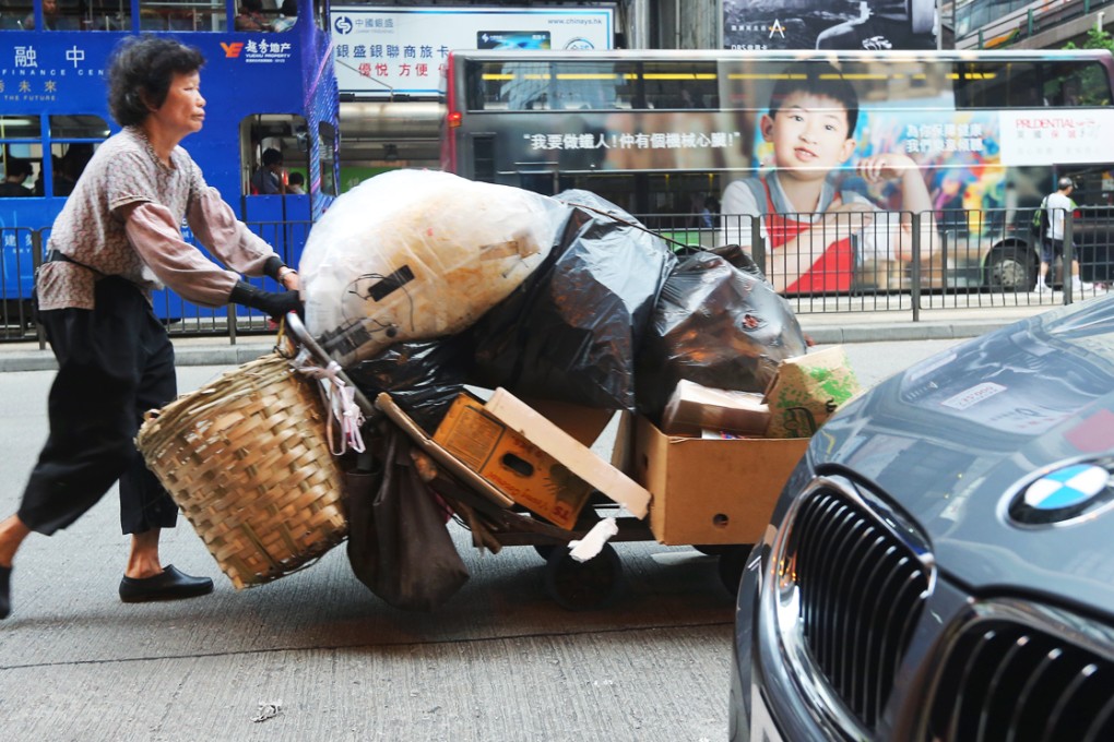A woman pushes a trolley full of rubbish on a street of Wan Chai. Photo: Sam Tsang