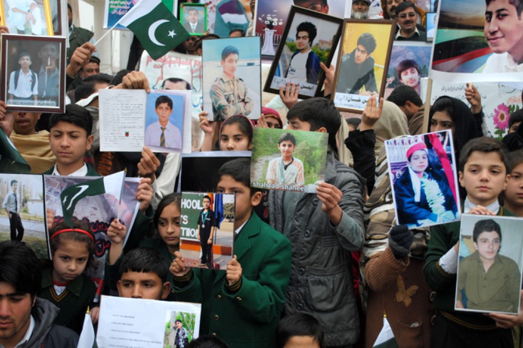 Students hold photographs of fellow pupils killed in a Taliban attack on the Army Public School in Peshawar, northwest Pakistan, in December. Photo: Xinhua