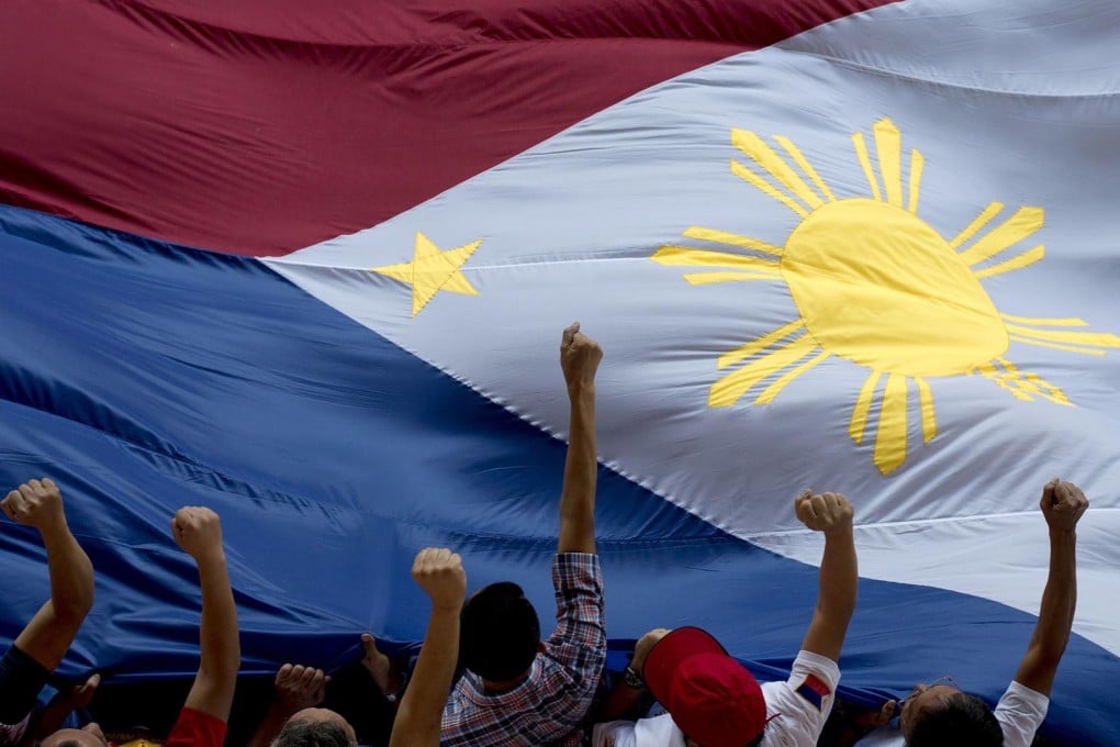 Protesters carry the national flag in Manila. President Benigno Aquino is under increasing pressure to step down over a botched anti-terror operation. Photo: AFP