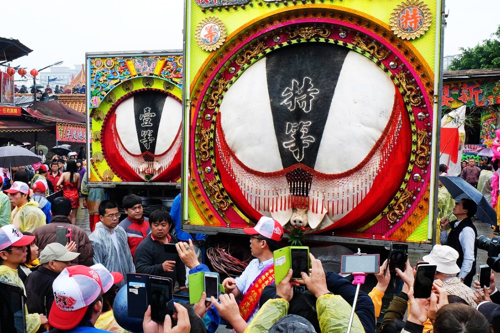 The pigs' bodies are displayed in brightly decorated vans. Photo: AFP