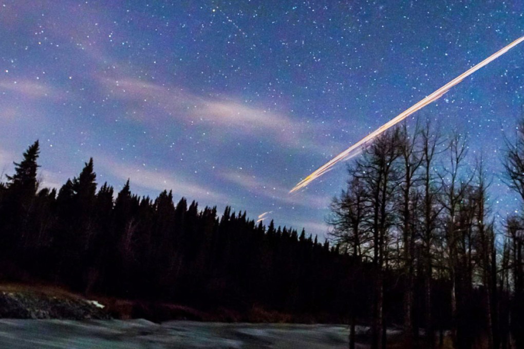 The orange streak of light is captured by photographer Neil Zeller as the Chinese rocket booster re-enters the atmosphere. Photo: AP