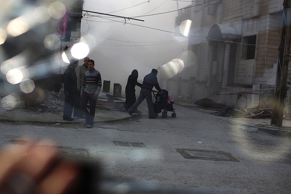A couple pushing a pram as they rush to check their house following a barrel bomb attack on an opposition-held area of the northern Syrian city of Aleppo. Photo: AFP