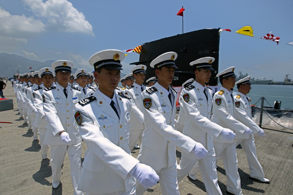 Members of the China People's Liberation Army march beside a navy submarine during a ceremony. Photo: Robert Ng