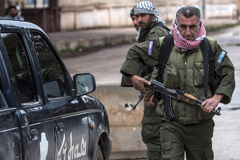 Christian fighters from the Kurdish militia man a checkpoint in the town of Tel Tamr in northeast Syria. Photo: Reuters