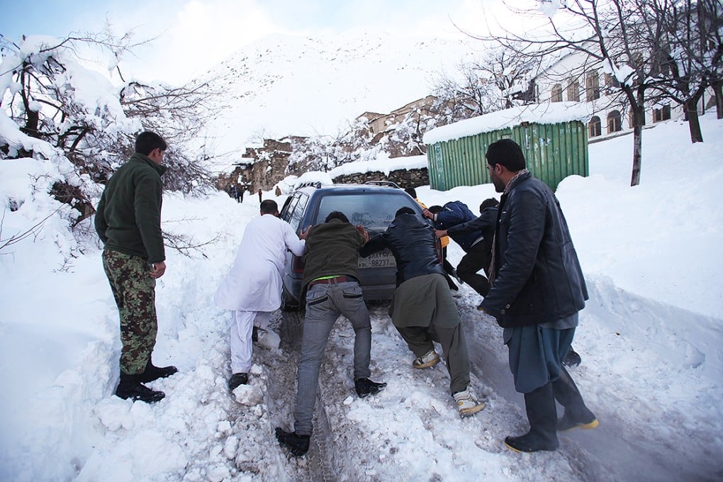 Local residents help push a vehicle stuck in snow in Panjshir province, eastern Afghanistan. Photo: Xinhua
