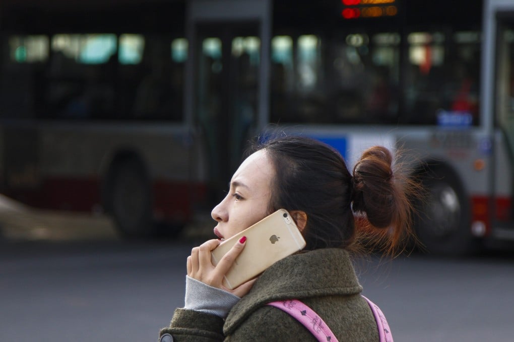 A woman speaks on her iPhone in Beijing. China has removed Apple from its list of approved state procurement vendors. Photo: EPA