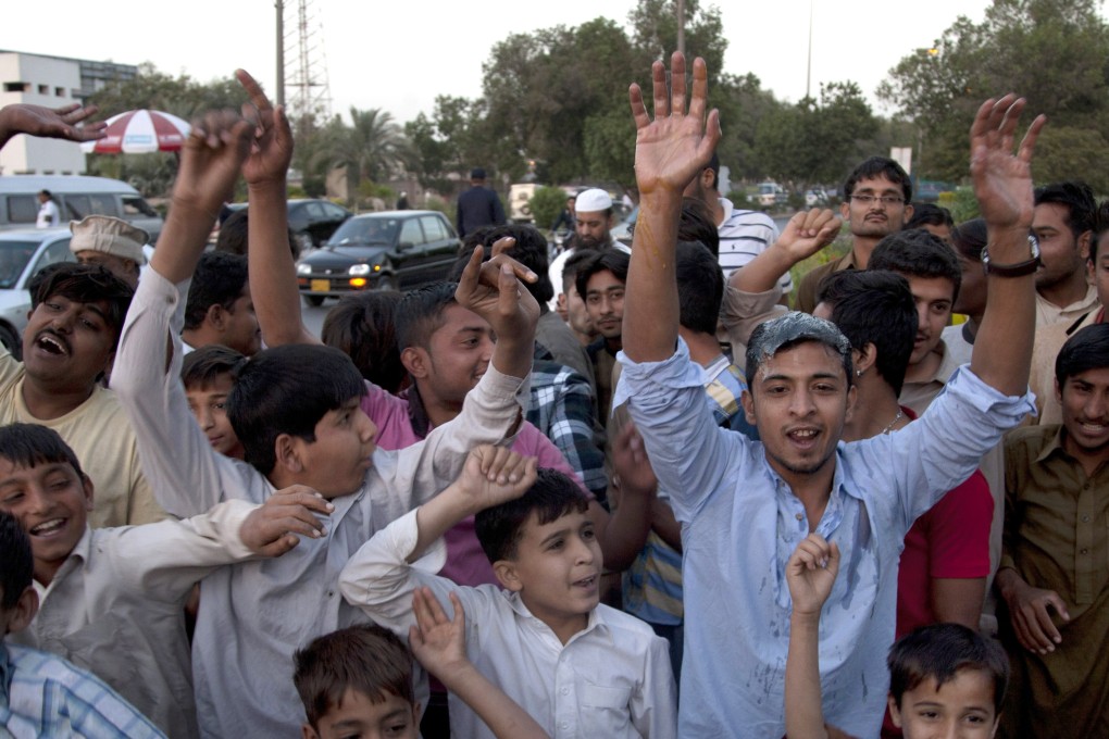 Pakistani fans chant slogans to protest against the country's chief selector, Moin Khan, at Karachi airport. Photo: AP