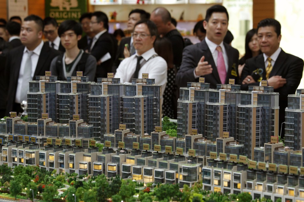 Property sales agents chat during the roadshow of a residential property development in Hong Kong. Photo: Reuters