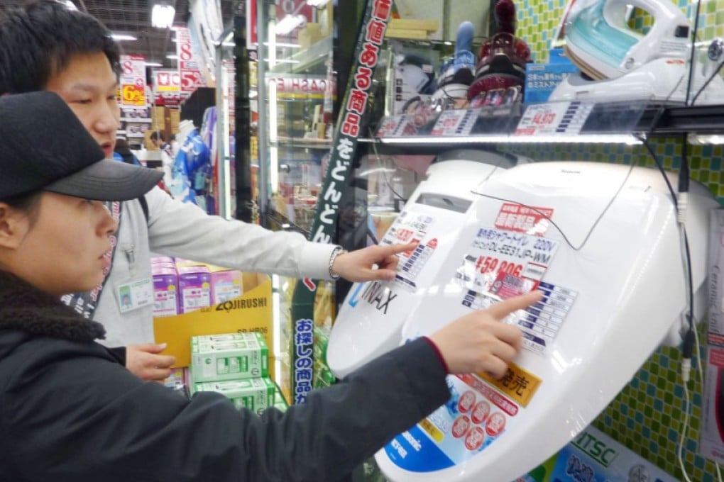 Chinese tourist learns how to use electronic toilet seat in Tokyo. Photo: Kyodo