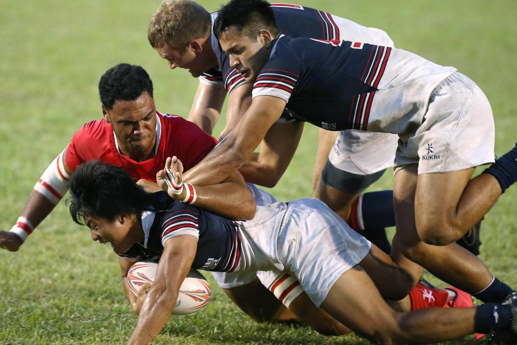 Hong Kong's Cado Lee Ka-to battles for possession against Tonga, backed by team-mates Nick Hewson and Michael Coverdale. Photos: HKRFU