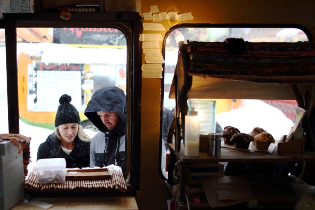 Visitors look at a menu displayed outside a food truck in Hokkaido, Japan. Photo: Bloomberg