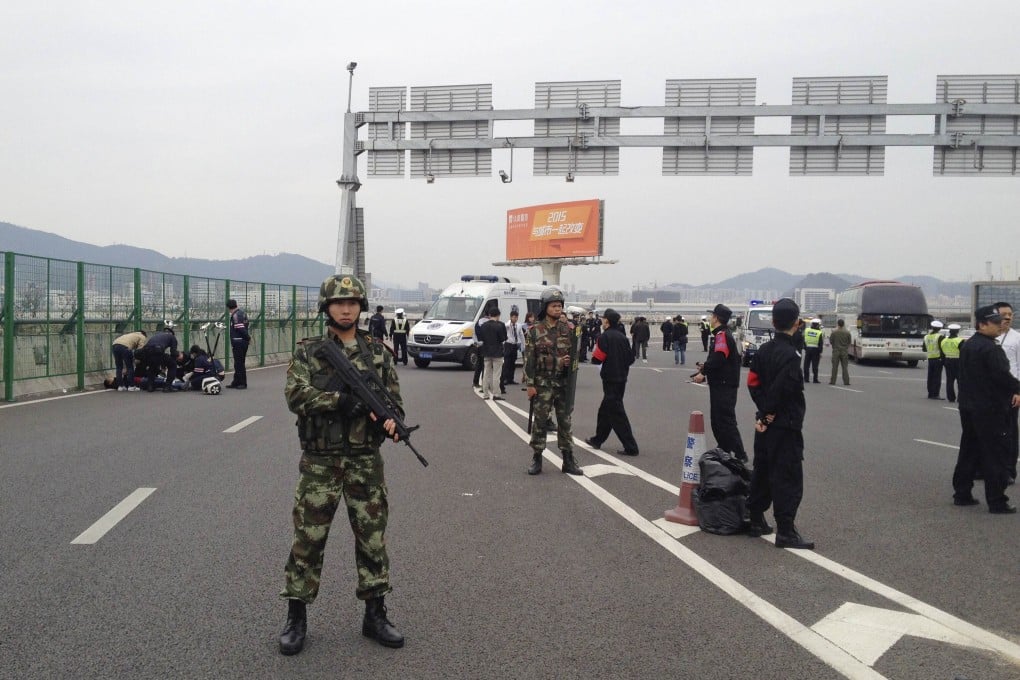 Armed police guard the scene of the accident yesterday in which nine people died and 23 others were injured when a car crashed into a group of people standing on an overpass to watch aircraft at Shenzhen Baoan International Airport. Photo: Reuters
