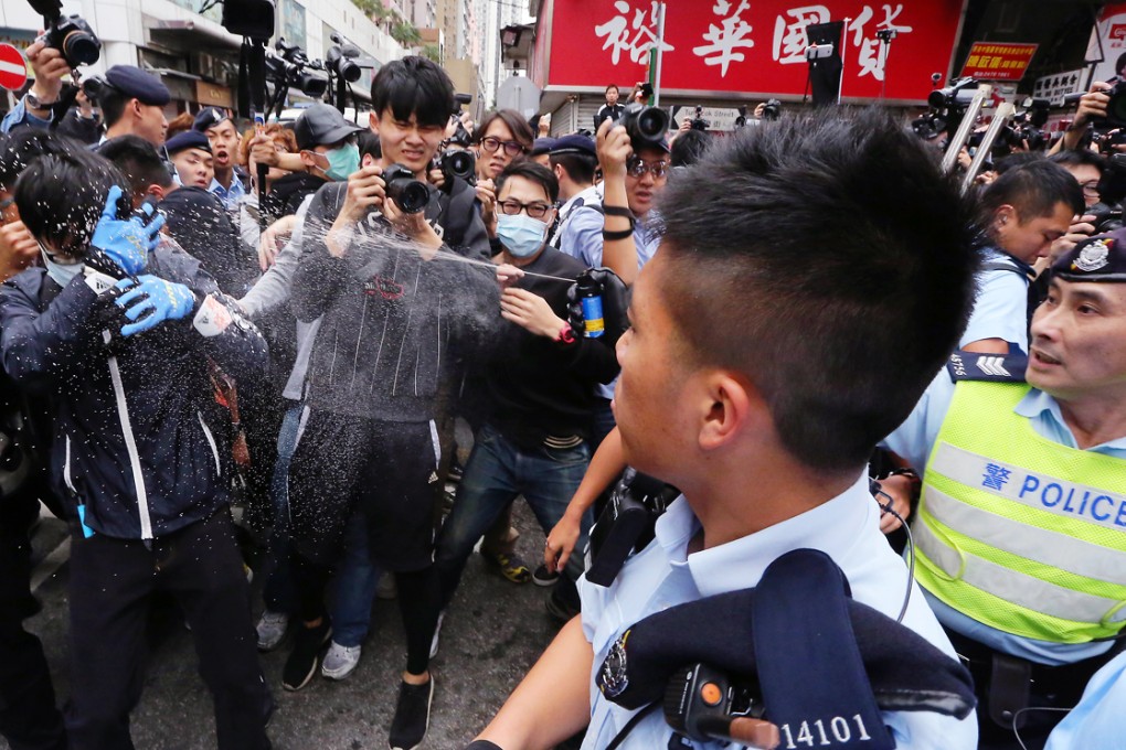 Police pepper spray protesters during yesterday's rally in Yuen Long, the latest in a series of protests aimed at traders from the mainland. Photo: Felix Wong