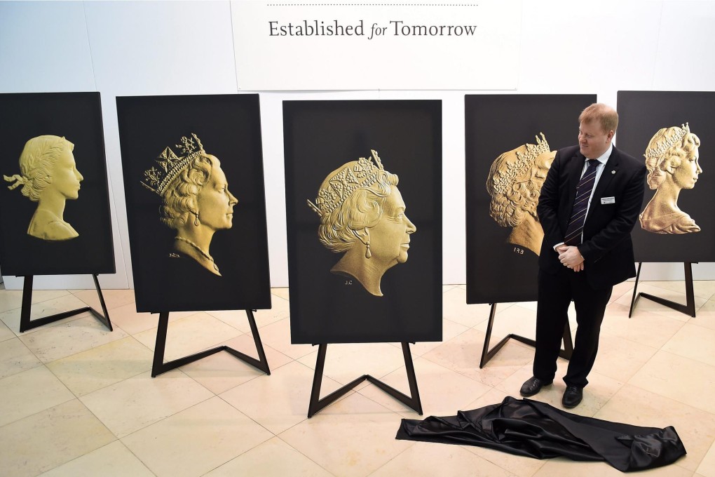 Adam Lawrence, chief executive of the British Royal Mint, stands among portraits depicting Queen Elizabeth II over the years.Photo: EPA